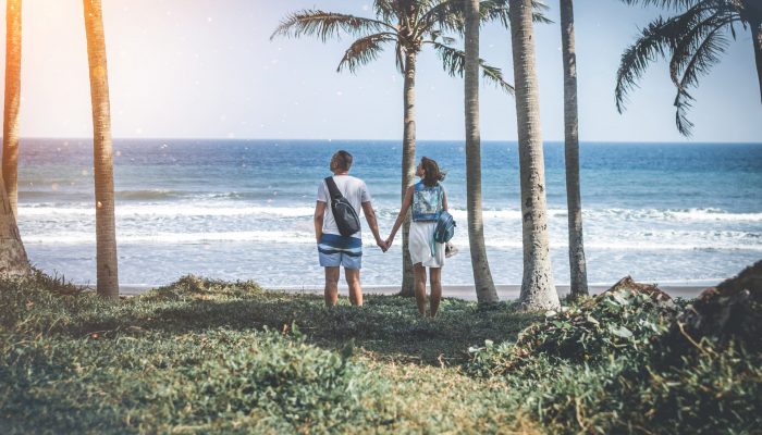 Young couple among palms on the tropical island of Bali. Indonesia.